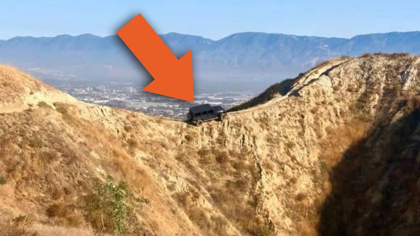 在加利福尼亚，有一辆吉普牧马人在一个傻瓜开上自行车道后悬挂在悬崖上
