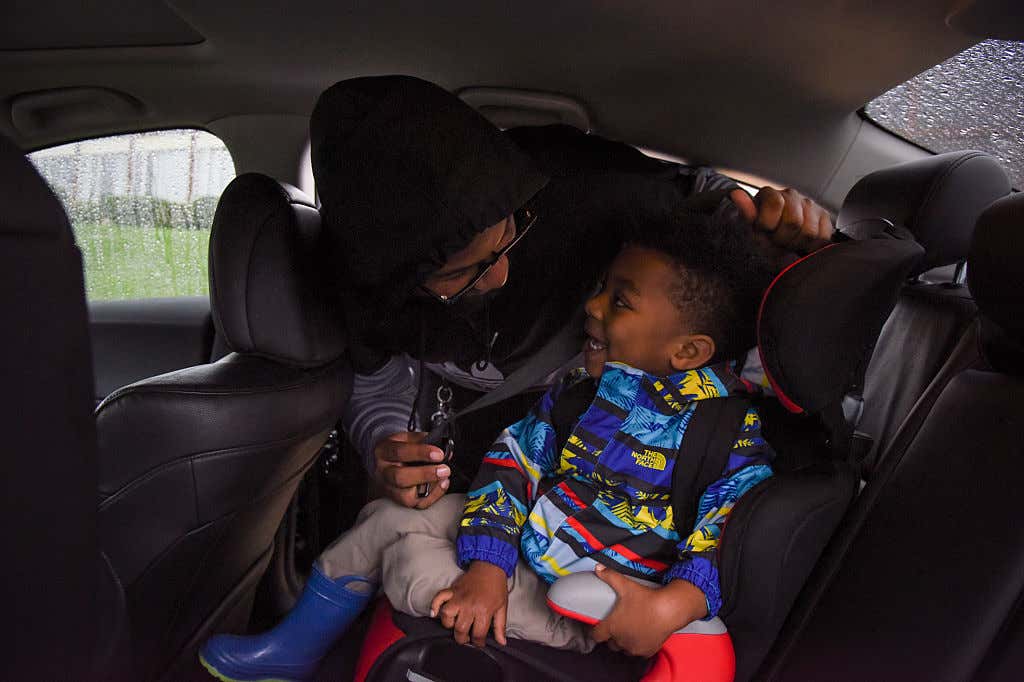 一位妈妈把她的小男孩扣在汽车座椅上。
