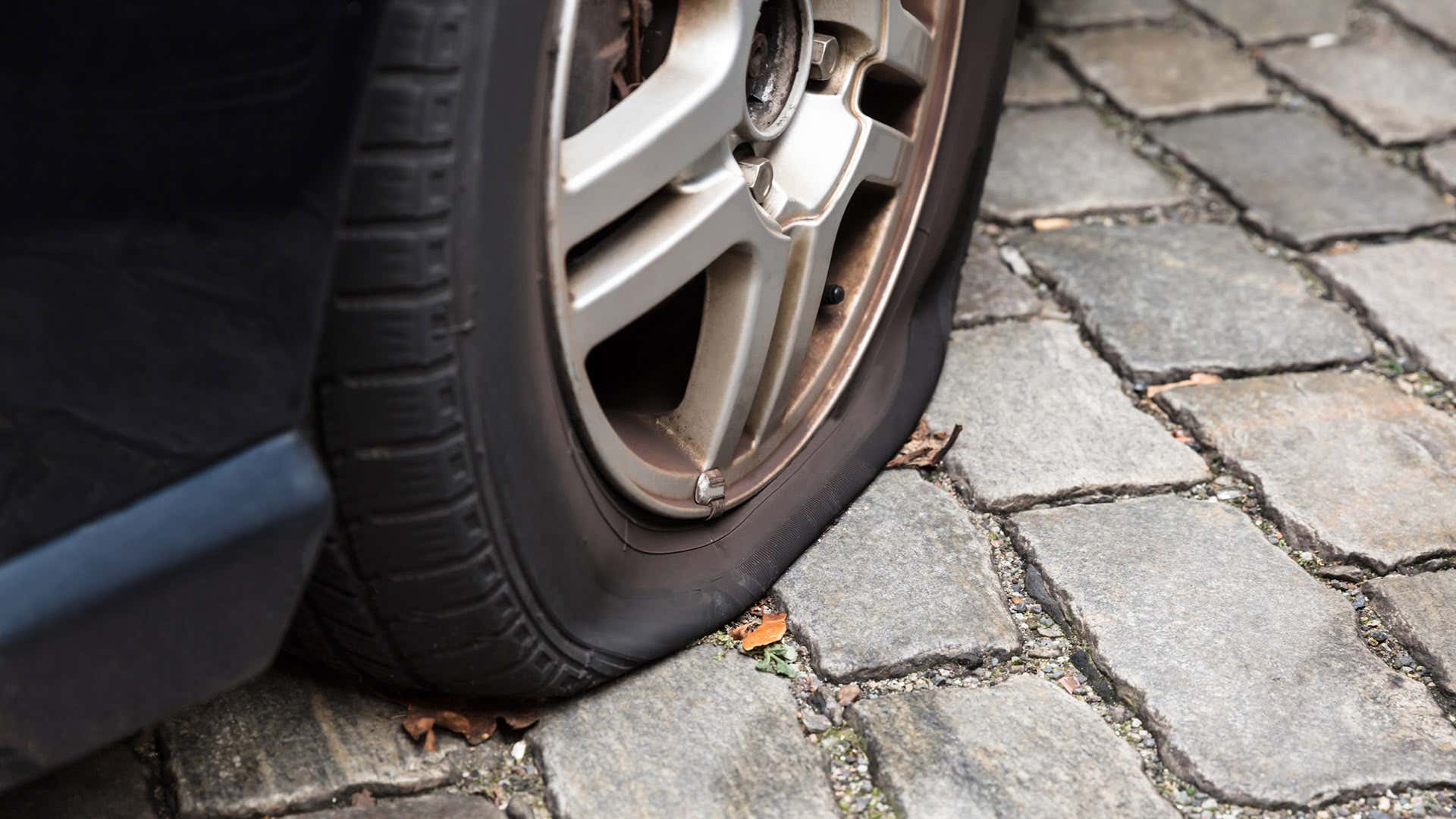砖块铺路石上有个漏气的轮胎。