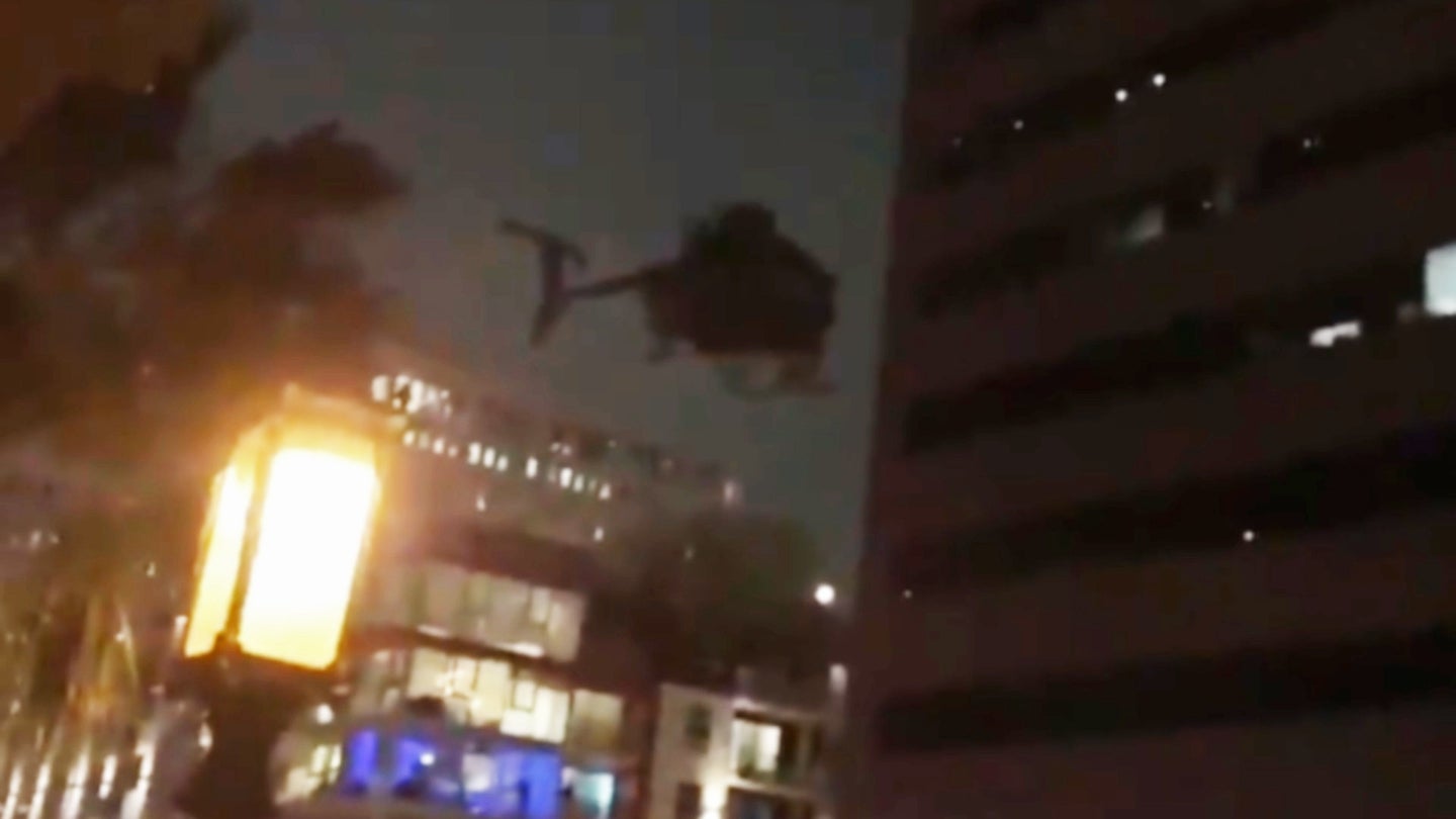 令人惊讶的视频，黑暗的夜间跟踪直升机嗡嗡低在洛杉矶市中心的街道