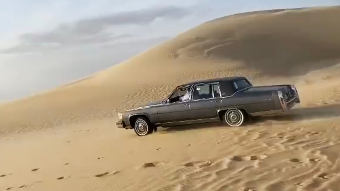 经典的卡迪拉克布鲁厄姆在沙丘上玩是为了羞辱你的举起的SUV